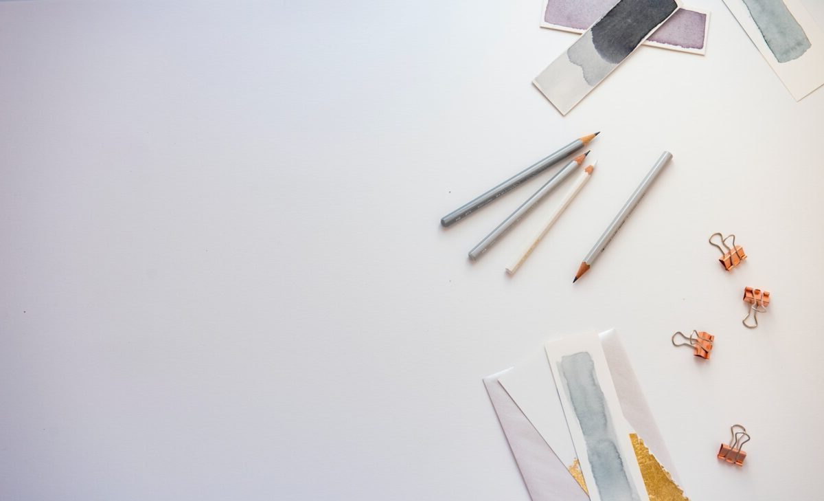 high angle photo of four pencils and greeting card